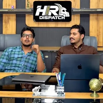 Two members of the HIR Dispatch team talking at the academy desk