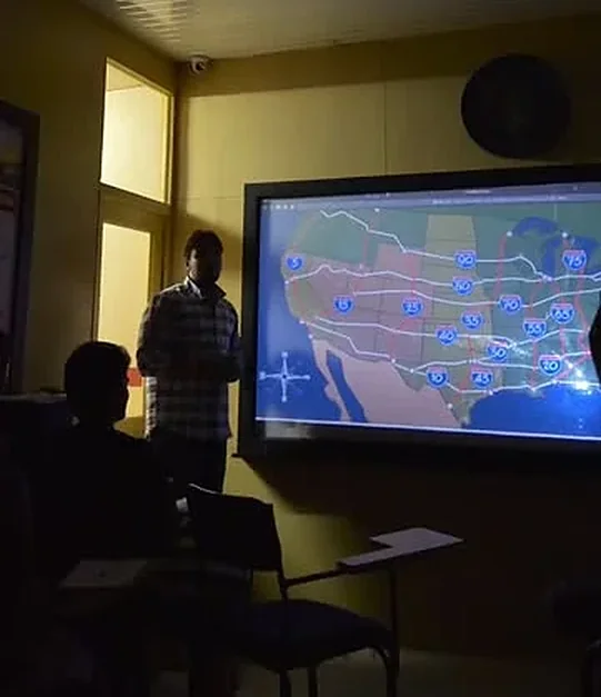 An HIR Dispatch Academy instructor presenting a map of US interstate freight routes to a class in Patran