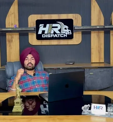 A mentor at the HIR Dispatch desk in the Patran centre, with the academy sign behind him